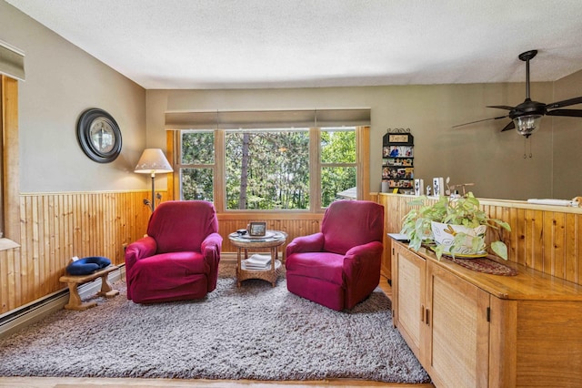 4745 Patterson Trl, Brainerd, MN 56401 - sitting room with wooden walls, wainscoting, a textured ceiling, a ceiling fan, and carpet flooring