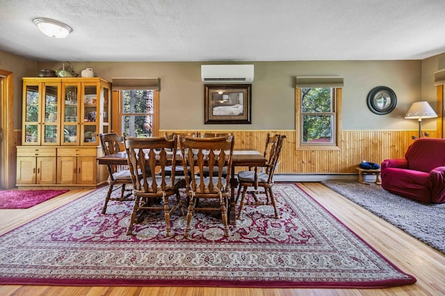 4745 Patterson Trl, Brainerd, MN 56401 - dining area with an AC wall unit, a wainscoted wall, a textured ceiling, wood finished floors, and wood walls