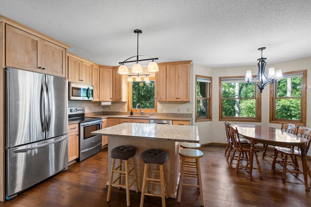621 Twelve Oaks Ln, Hudson, WI 54016 - kitchen featuring stainless steel appliances, light brown cabinets, a chandelier, dark wood-style floors, and a textured ceiling