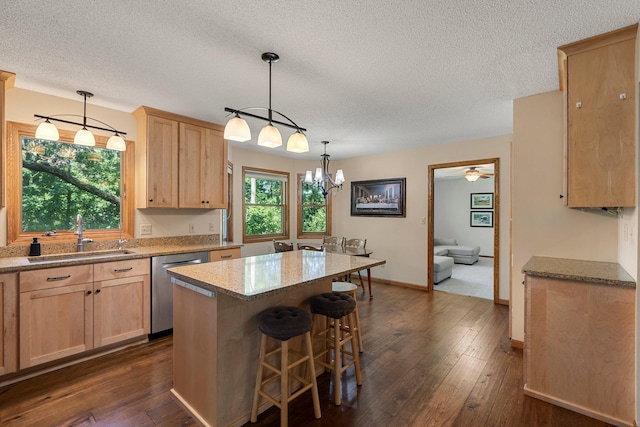 621 Twelve Oaks Ln, Hudson, WI 54016 - kitchen with stainless steel dishwasher, light brown cabinetry, a textured ceiling, dark wood-style flooring, and a breakfast bar area