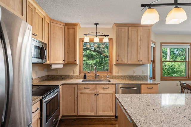 621 Twelve Oaks Ln, Hudson, WI 54016 - kitchen with stainless steel appliances, light brown cabinetry, light stone countertops, and a textured ceiling