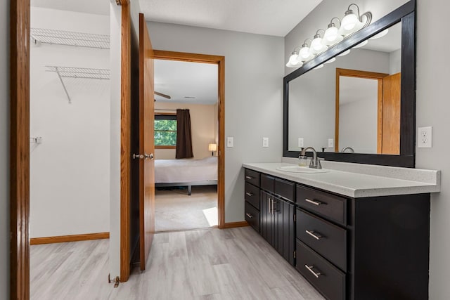 621 Twelve Oaks Ln, Hudson, WI 54016 - bathroom featuring wood finished floors, vanity, ensuite bathroom, and a spacious closet