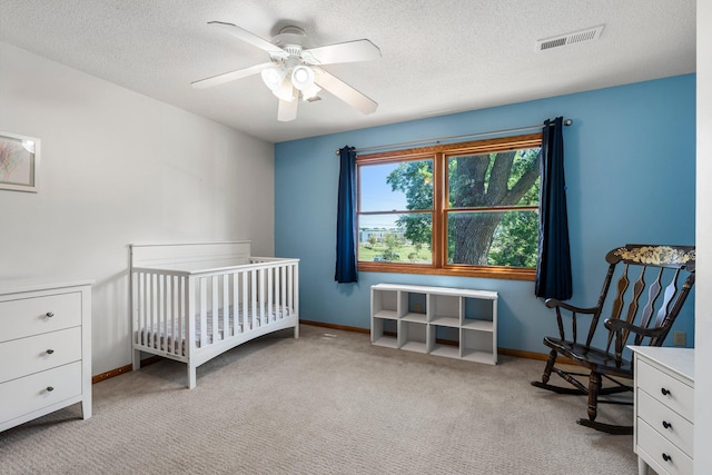 621 Twelve Oaks Ln, Hudson, WI 54016 - carpeted bedroom featuring a textured ceiling, a ceiling fan, and a nursery area