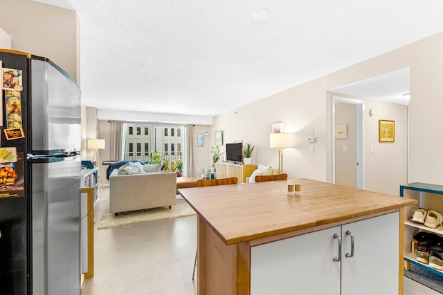 121 Washington Ave S Unit 513, Minneapolis, MN 55401 - kitchen featuring freestanding refrigerator, open floor plan, a textured ceiling, a kitchen island, and wooden counters