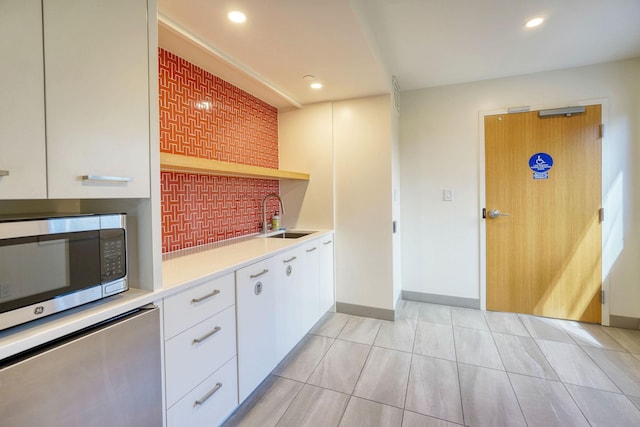 121 Washington Ave S Unit 513, Minneapolis, MN 55401 - kitchen with stainless steel microwave, light countertops, white cabinets, recessed lighting, and light tile patterned floors