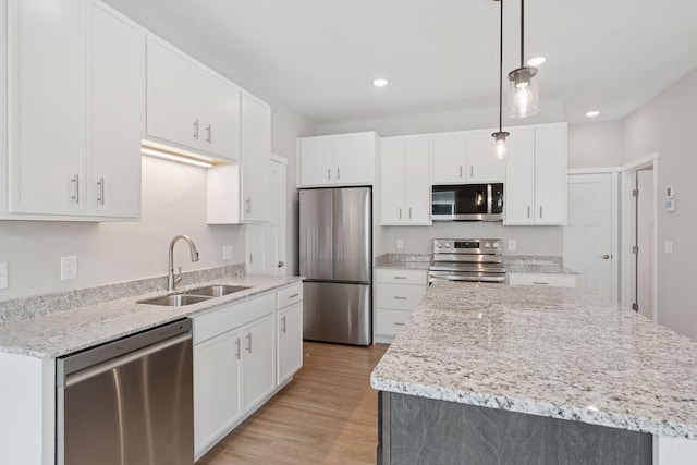 2728 229th Ln NW, Saint Francis, MN 55070 - kitchen with appliances with stainless steel finishes, light wood-type flooring, a kitchen island, white cabinetry, and recessed lighting