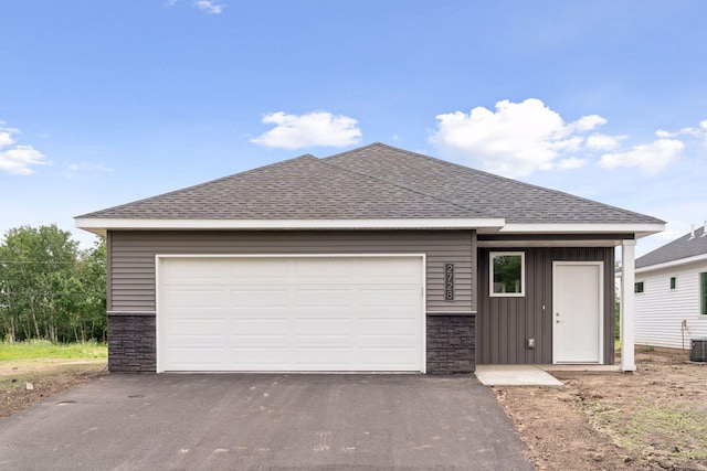 2728 229th Ln NW, Saint Francis, MN 55070 - ranch-style home featuring stone siding, roof with shingles, asphalt driveway, an attached garage, and board and batten siding