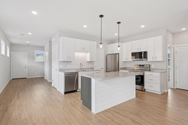 2728 229th Ln NW, Saint Francis, MN 55070 - kitchen with appliances with stainless steel finishes, a kitchen island, light wood-style floors, white cabinets, and recessed lighting