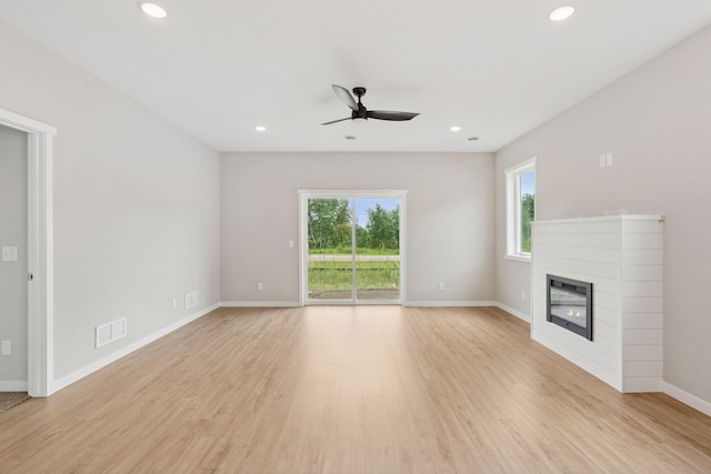 2728 229th Ln NW, Saint Francis, MN 55070 - unfurnished living room featuring ceiling fan, light wood-style floors, a glass covered fireplace, and recessed lighting