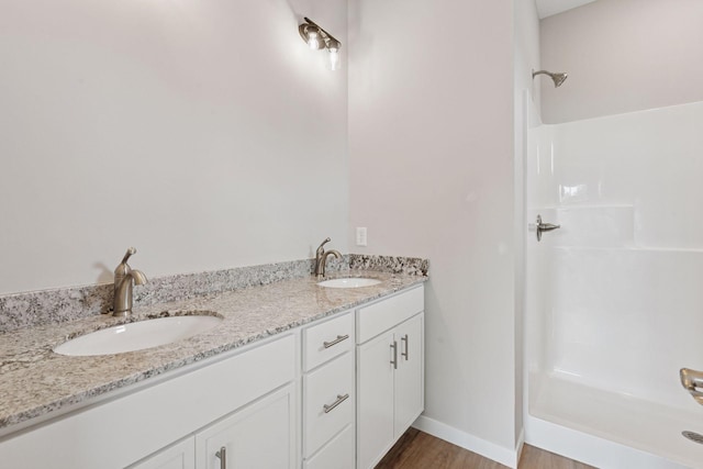 2728 229th Ln NW, Saint Francis, MN 55070 - bathroom featuring a shower, double vanity, and wood finished floors