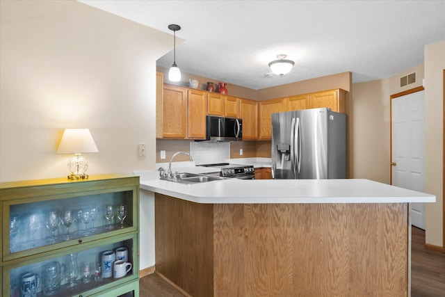 8731 Quarry Ridge Ln Unit B, Woodbury, MN 55125 - kitchen featuring stainless steel appliances, a peninsula, light countertops, and dark wood-type flooring