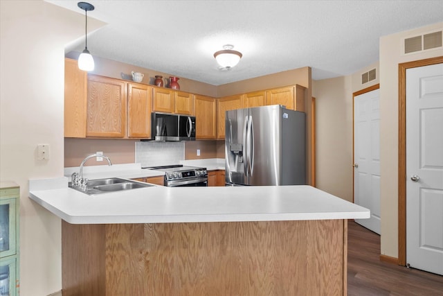 8731 Quarry Ridge Ln Unit B, Woodbury, MN 55125 - kitchen with stainless steel appliances, a peninsula, light countertops, dark wood finished floors, and decorative backsplash