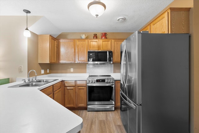 8731 Quarry Ridge Ln Unit B, Woodbury, MN 55125 - kitchen with stainless steel appliances, light wood finished floors, light countertops, hanging light fixtures, and backsplash