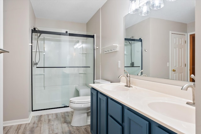 8731 Quarry Ridge Ln Unit B, Woodbury, MN 55125 - full bathroom with wood finished floors, a stall shower, and double vanity