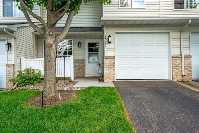 8731 Quarry Ridge Ln Unit B, Woodbury, MN 55125 - view of exterior entry with a garage, asphalt driveway, and brick siding
