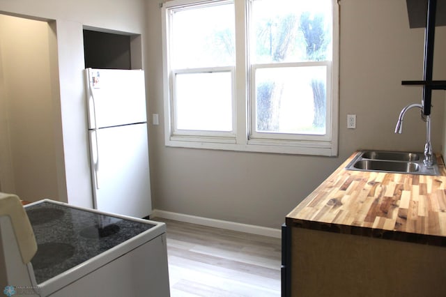 921 6th Ave N, Fargo, ND 58102 - kitchen with white appliances, butcher block counters, light wood-style floors, and healthy amount of natural light