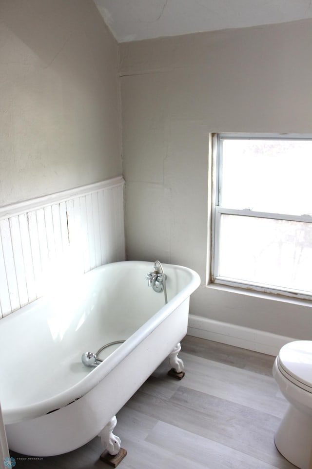 921 6th Ave N, Fargo, ND 58102 - full bathroom featuring a freestanding bath, wood finished floors, and a wainscoted wall