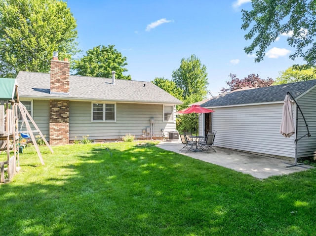 1917 2nd Ave NW, Austin, MN 55912 - back of house with a patio, a playground, a chimney, and a yard