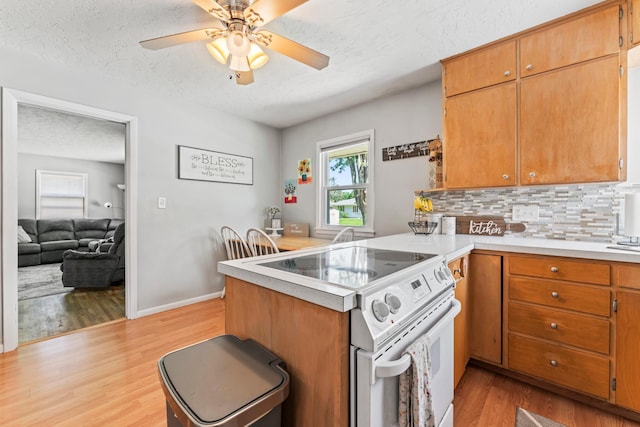 1917 2nd Ave NW, Austin, MN 55912 - kitchen with electric stove, a peninsula, decorative backsplash, a textured ceiling, and light wood-style floors