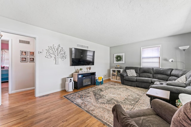 1917 2nd Ave NW, Austin, MN 55912 - living room featuring a textured ceiling and light wood-style floors