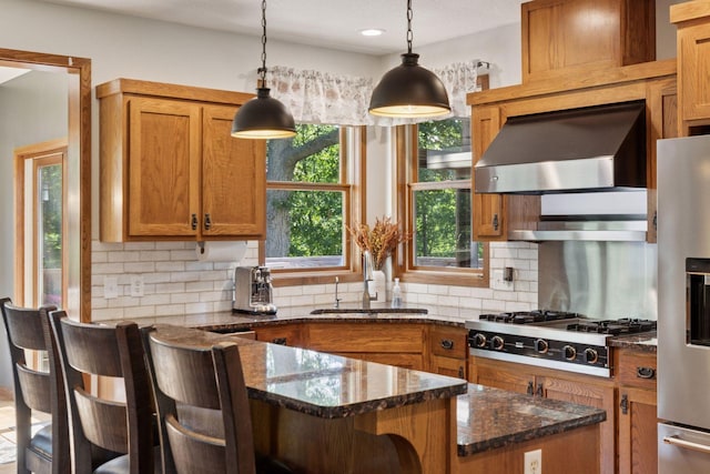 11985 Lever Ct NE, Blaine, MN 55449 - kitchen with appliances with stainless steel finishes, wall chimney exhaust hood, decorative backsplash, a kitchen bar, and pendant lighting