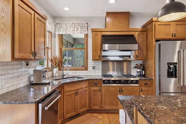 11985 Lever Ct NE, Blaine, MN 55449 - kitchen featuring appliances with stainless steel finishes, wall chimney range hood, brown cabinetry, light wood-style flooring, and recessed lighting