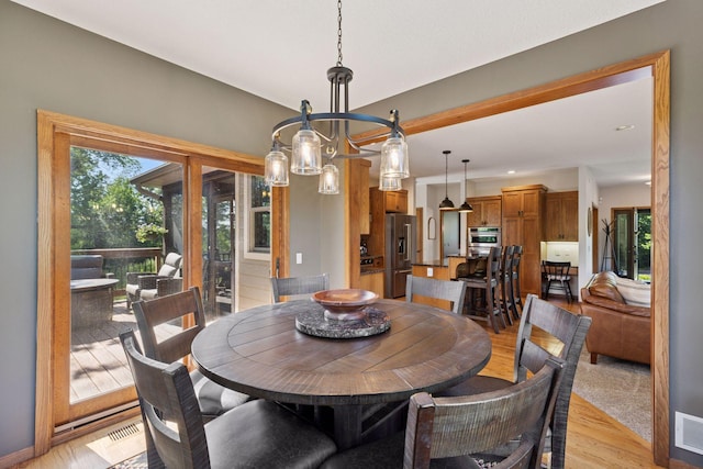 11985 Lever Ct NE, Blaine, MN 55449 - dining space featuring light wood finished floors and a chandelier