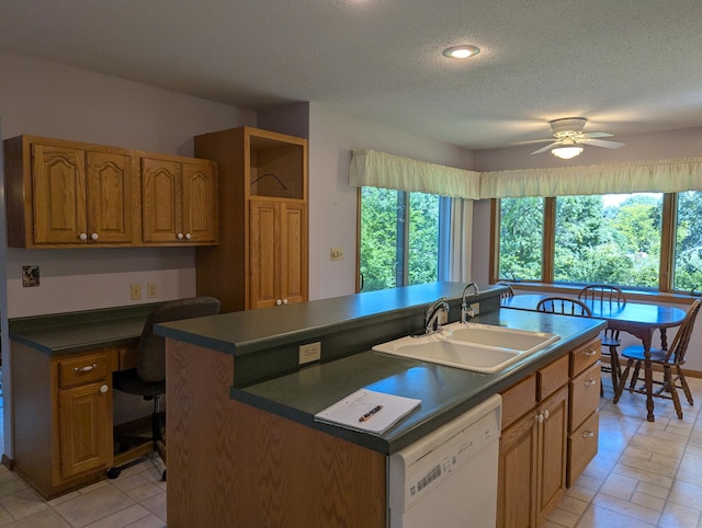 417 Ridge Rd, Albert Lea, MN 56007 - kitchen featuring white dishwasher, built in desk, dark countertops, plenty of natural light, and a textured ceiling