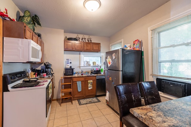 803 5th St, Winona, MN 55987 - kitchen with stainless steel appliances, brown cabinetry, light tile patterned floors, and a textured ceiling
