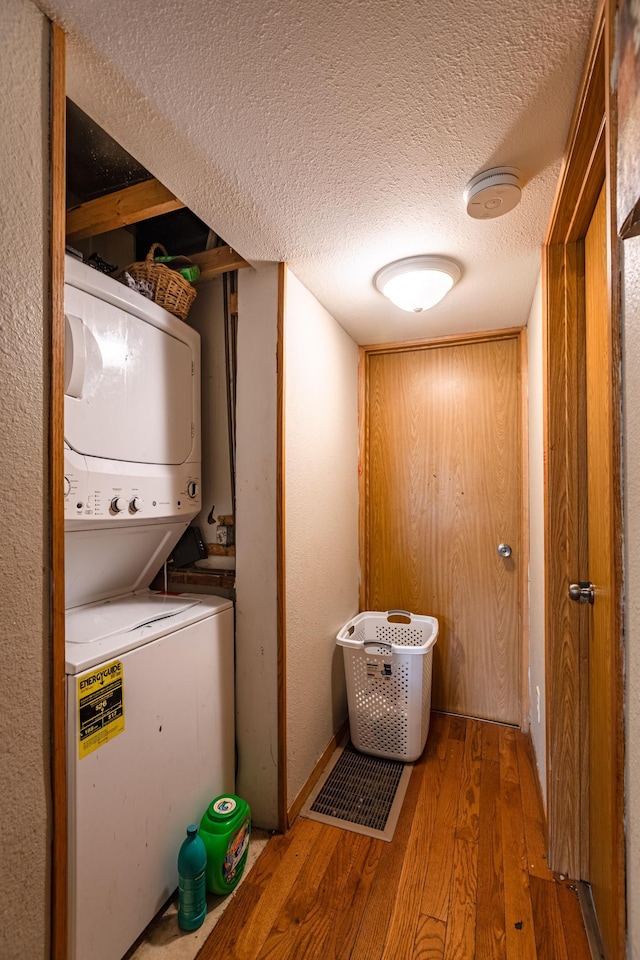 803 5th St, Winona, MN 55987 - laundry area with stacked washer / drying machine, hardwood / wood-style flooring, and a textured ceiling