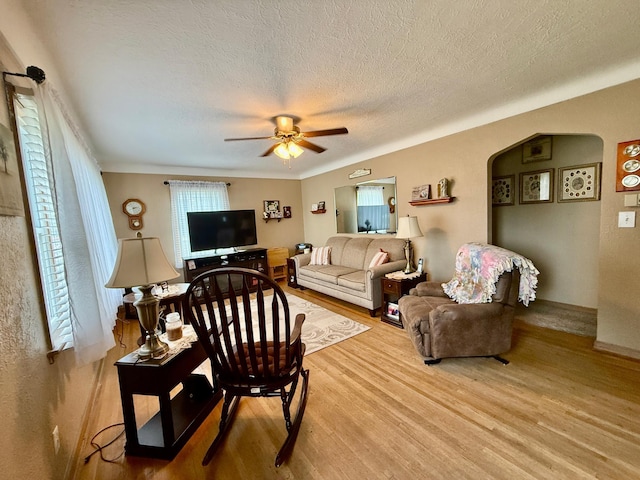 905 Clausen Ave, Albert Lea, MN 56007 - living area featuring wood finished floors, ceiling fan, arched walkways, and a textured ceiling