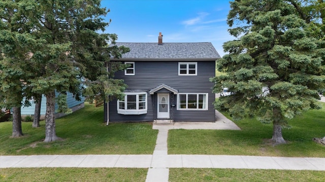 602 8th St NW, Chisholm, MN 55719 - view of front of home with a chimney, a front lawn, and roof with shingles