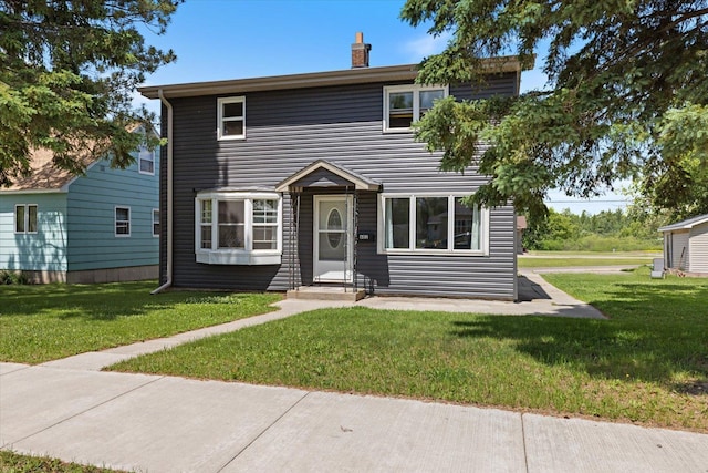 602 8th St NW, Chisholm, MN 55719 - traditional-style home with a front yard, a chimney, and entry steps