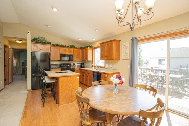 2223 Fairbanks Dr, North Mankato, MN 56003 - kitchen featuring black appliances, a chandelier, lofted ceiling, a kitchen island, and light countertops