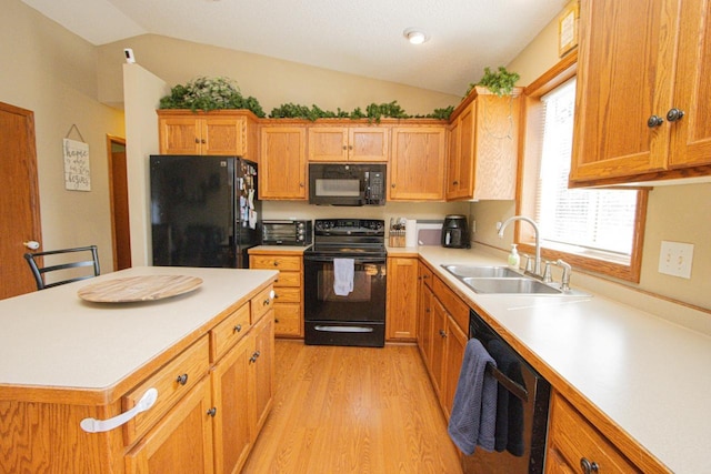 2223 Fairbanks Dr, North Mankato, MN 56003 - kitchen with black appliances, lofted ceiling, light wood-style floors, light countertops, and a center island