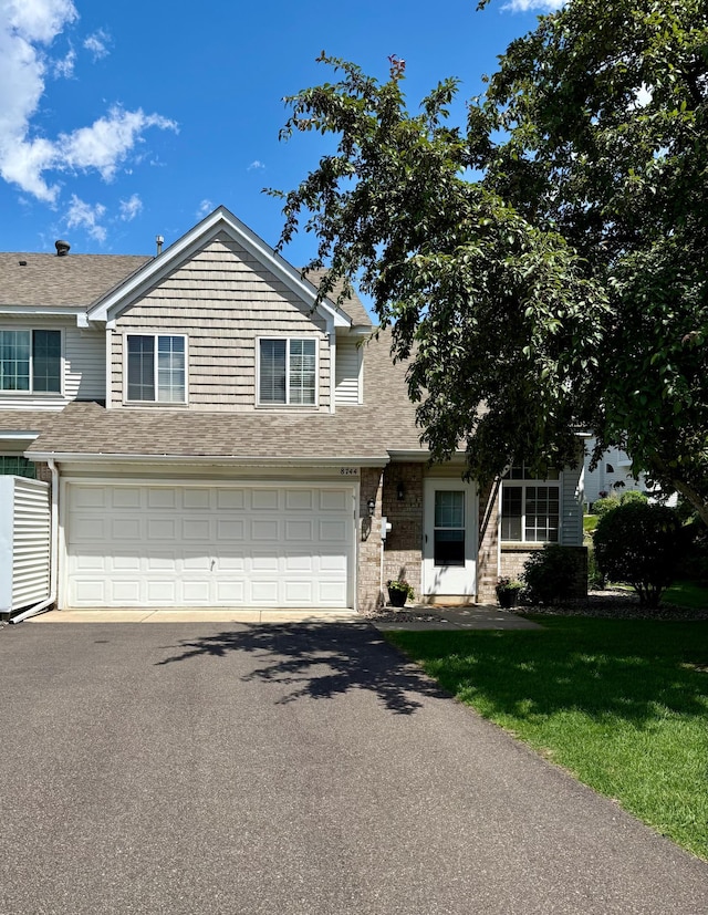 8744 Bechtel Ave Unit 109, Inver Grove Heights, MN 55076 - traditional-style home featuring driveway, an attached garage, a shingled roof, and a front lawn