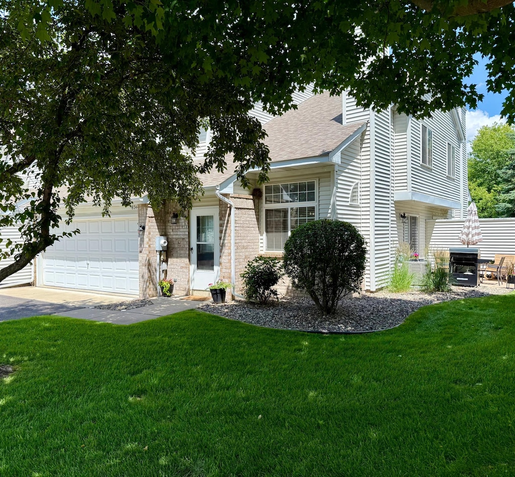 8744 Bechtel Ave Unit 109, Inver Grove Heights, MN 55076 - view of front of home featuring a front yard, a shingled roof, a garage, and driveway