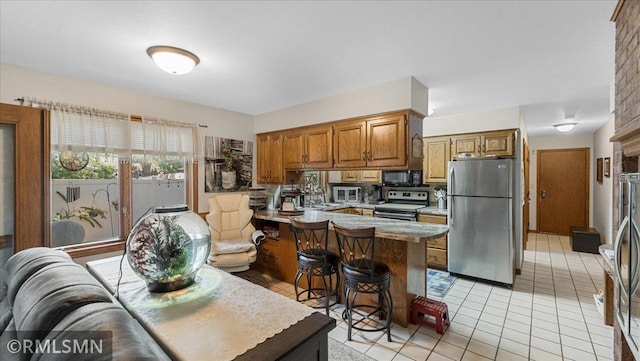 950 Tuva Rd SE, Cokato, MN 55321 - kitchen featuring appliances with stainless steel finishes, light tile patterned flooring, brown cabinets, a kitchen bar, and light countertops