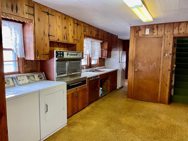16140 Central Ave NE, Ham Lake, MN 55304 - kitchen featuring washing machine and dryer, black dishwasher, freestanding refrigerator, light countertops, and wood walls