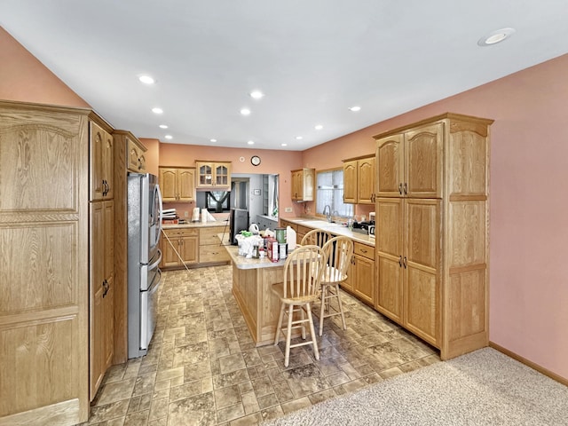 3018 Linden Ave, Slayton, MN 56172 - kitchen with a kitchen island, freestanding refrigerator, light countertops, a breakfast bar, and glass insert cabinets