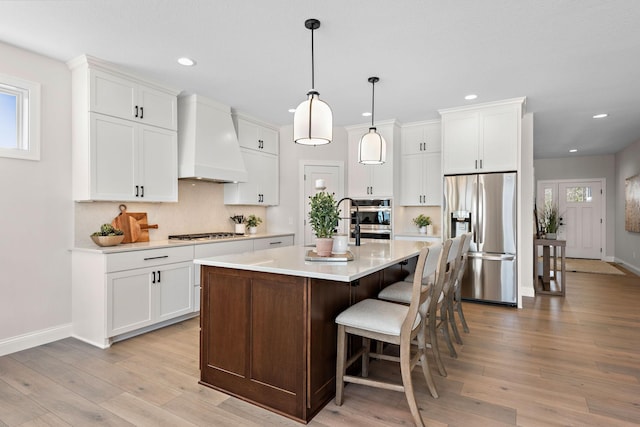 3886 Larabee Ave NE, Saint Michael, MN 55376 - kitchen with stainless steel appliances, premium range hood, light countertops, recessed lighting, and white cabinetry