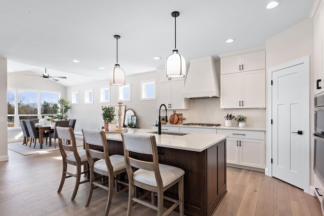 3886 Larabee Ave NE, Saint Michael, MN 55376 - kitchen featuring custom range hood, stainless steel appliances, a kitchen island with sink, light countertops, and a kitchen bar
