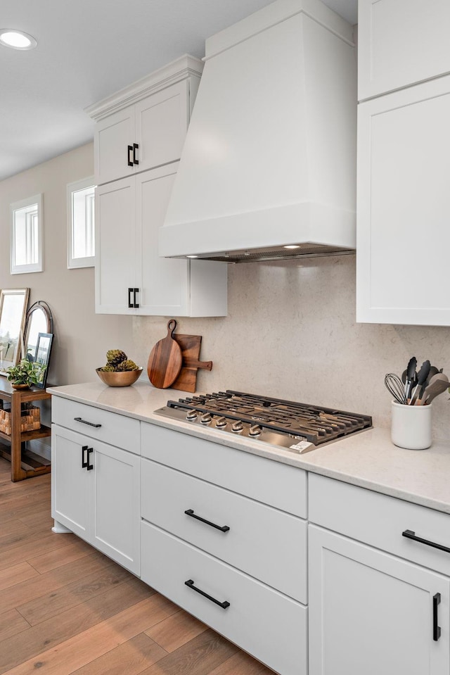 3886 Larabee Ave NE, Saint Michael, MN 55376 - kitchen with stainless steel gas cooktop, premium range hood, light countertops, backsplash, and white cabinetry