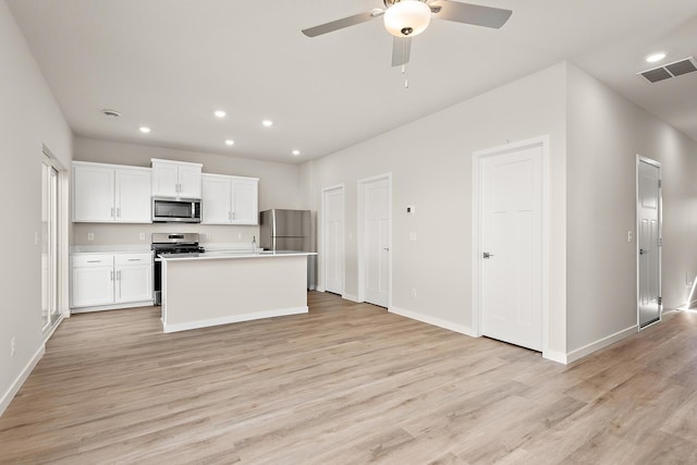 39749 Fallbrook Ave, North Branch, MN 55056 - kitchen with appliances with stainless steel finishes, light wood-style flooring, a ceiling fan, white cabinets, and recessed lighting
