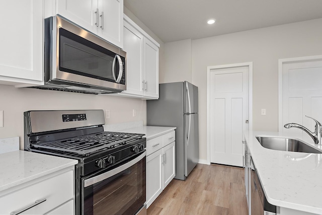 39749 Fallbrook Ave, North Branch, MN 55056 - kitchen with appliances with stainless steel finishes, white cabinets, light wood-style floors, light stone counters, and recessed lighting