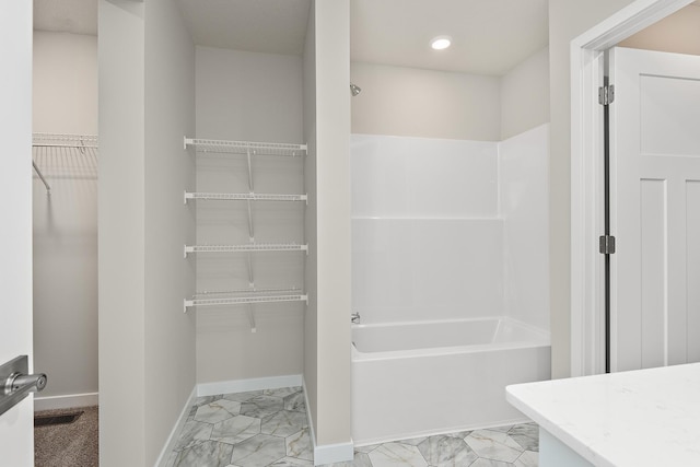 39749 Fallbrook Ave, North Branch, MN 55056 - bathroom featuring marble look tiles, a walk in closet, washtub / shower combination, vanity, and recessed lighting