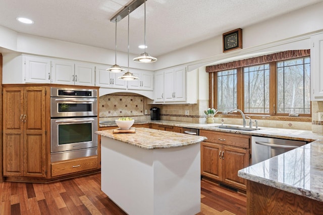 3600 Wedgewood Ln N, Plymouth, MN 55441 - kitchen featuring appliances with stainless steel finishes, backsplash, dark wood-style flooring, a center island, and hanging light fixtures
