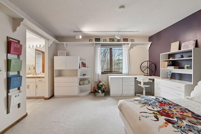 3600 Wedgewood Ln N, Plymouth, MN 55441 - bedroom featuring light colored carpet, track lighting, ensuite bath, a textured ceiling, and an office area