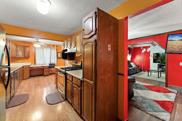 7609 James Ave N, Brooklyn Park, MN 55444 - kitchen with appliances with stainless steel finishes, a textured ceiling, light countertops, and light wood-style floors