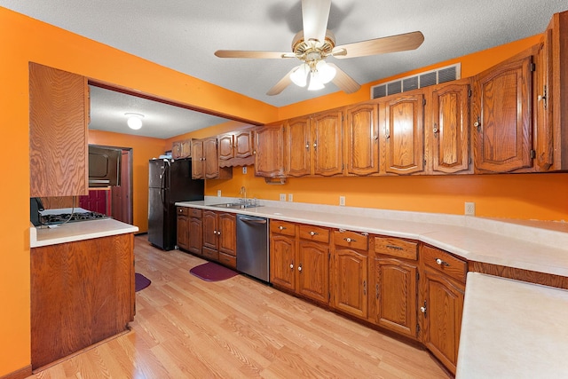 7609 James Ave N, Brooklyn Park, MN 55444 - kitchen with brown cabinetry, light wood-style flooring, a ceiling fan, dishwasher, and freestanding refrigerator